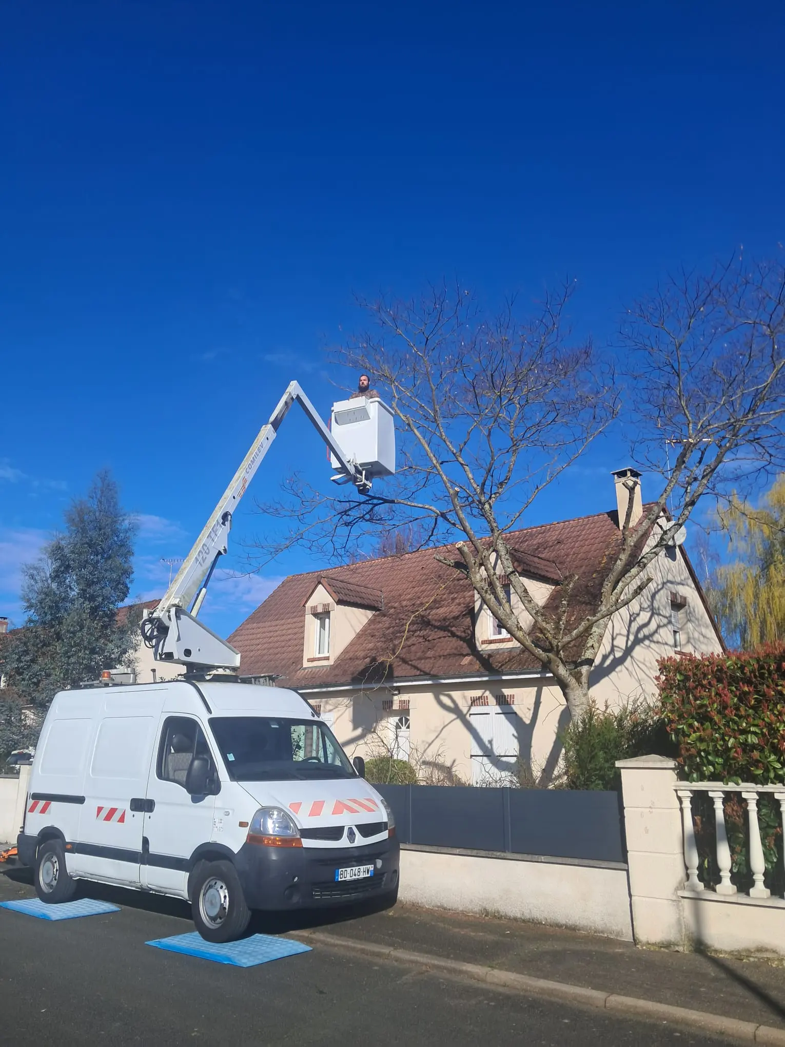 Image d'un chantier en cours pour l'élagage d'un arbre dans une cours nécessitant l'utilisation d'une nacelle pour un client à Orléans